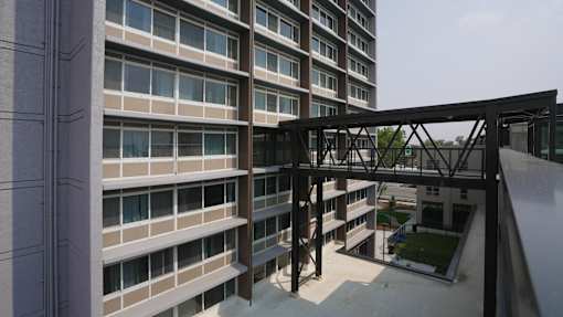 A modern building with a metal walkway connecting the floors at Denver Metro Village Apartments, Denver, Colorado