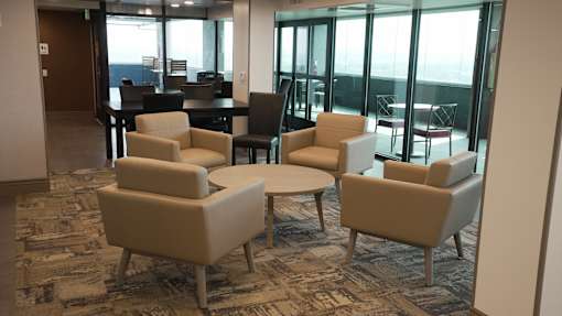 A room with a carpeted floor and a table with chairs at Denver Metro Village Apartments, Colorado