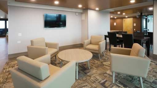 A living room with a couch, chairs, and a television at Denver Metro Village Apartments, Colorado, 80204