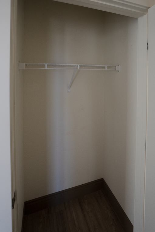 Empty white closet with a shelf and a door at Denver Metro Village Apartments, Denver, CO