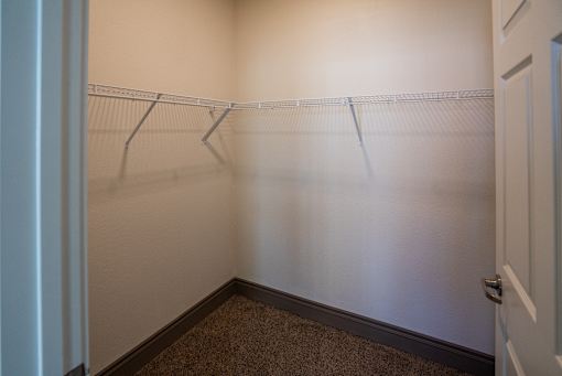 A white door with a handle and a white wall with a shelf at Denver Metro Village Apartments, Colorado, 80204