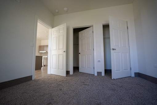 A room with white doors and carpeted floor at Denver Metro Village Apartments, Denver, CO
