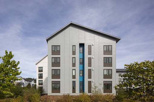 A modern building with a white facade and a blue door.
