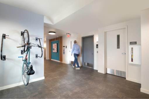 A hallway with a bicycle rack and a person walking.