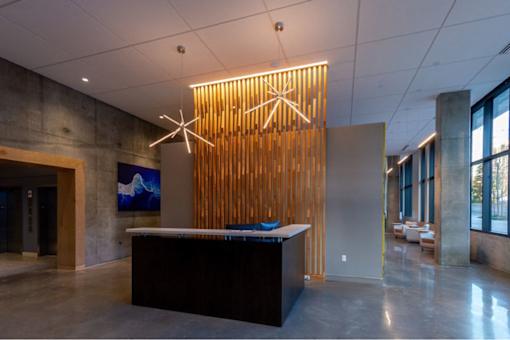 A reception area with a black counter and a wooden wall panel.