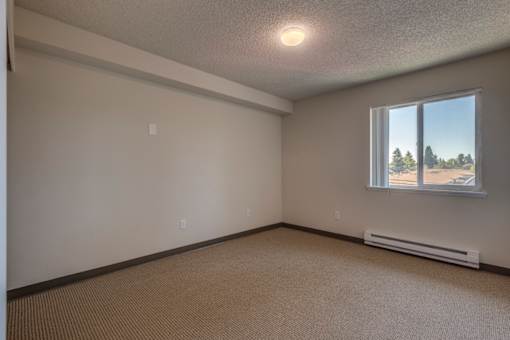 A room with a window and a wall-mounted air conditioner.