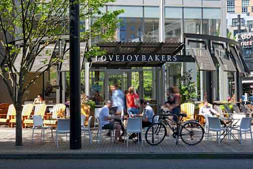 A bakery named Lovejoybakers has a patio with people sitting and eating.