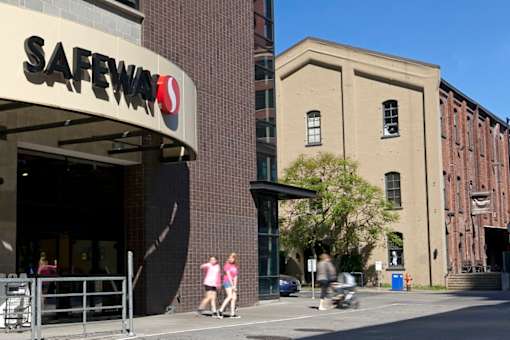 Safeway store with people walking in front.