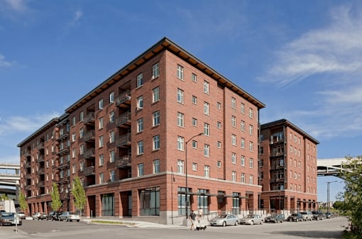 A large red brick building with a parking lot in front.