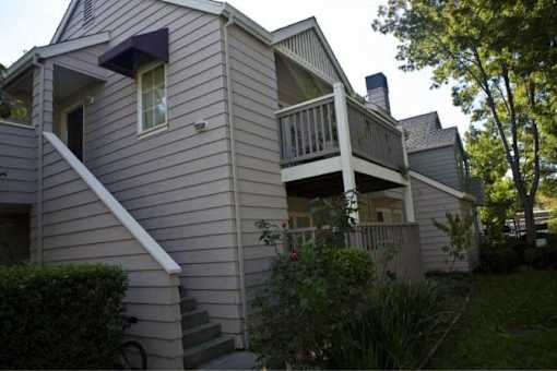 A house with a balcony and a staircase leading to the second floor.