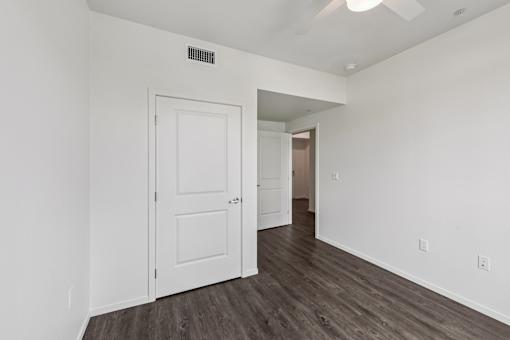 A white door is in a room with wood flooring.