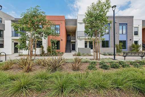 A modern building with a landscaped front yard.