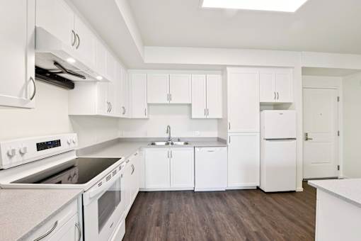 A kitchen with white appliances and cabinets.
