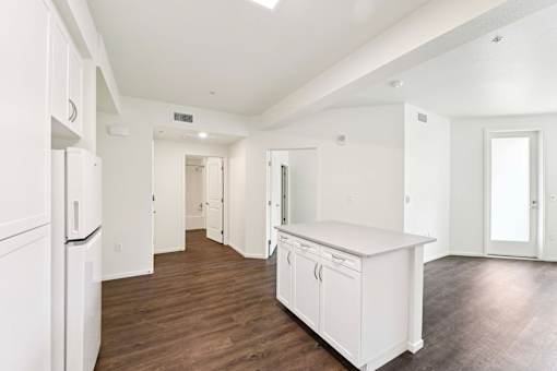 A kitchen with white appliances and cabinets.