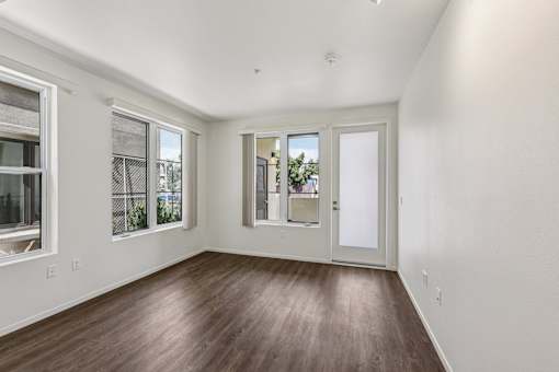A room with a white wall and a brown floor.