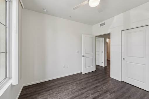 A room with white walls and a window on the left side.