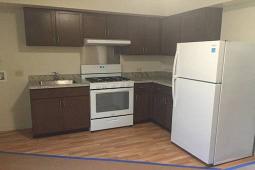 A kitchen with brown cabinets and a white fridge.