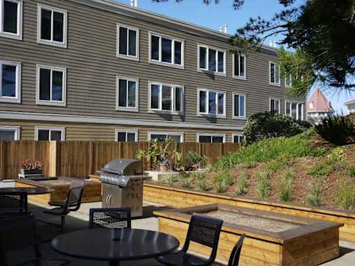 A patio with a table and chairs is in front of a building.