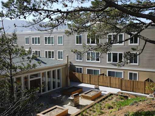 A view of a backyard with a wooden deck and a fence.