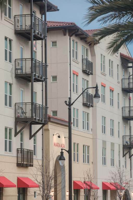 A tall building with a balcony on the second floor.