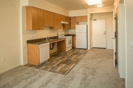 A kitchen with a white fridge and wooden cabinets.