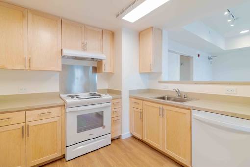 A kitchen with wooden cabinets and a white stove top oven.