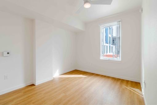 A room with a window and wooden flooring.