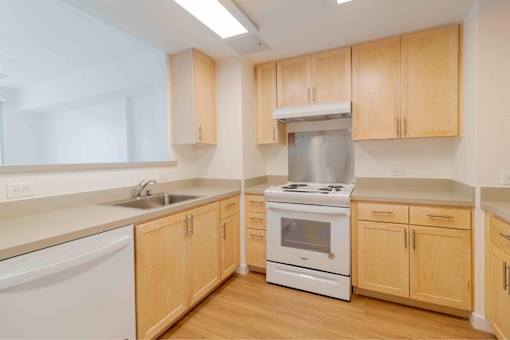 A kitchen with wooden cabinets and white appliances.