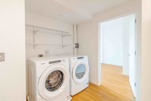 Two white front loading washing machines in a laundry room.