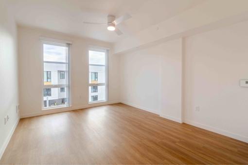 A room with wooden floors and two windows.