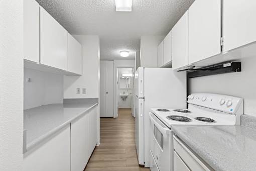A white kitchen with a stove and cabinets.