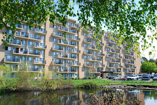 A large building with many windows is reflected in the water.