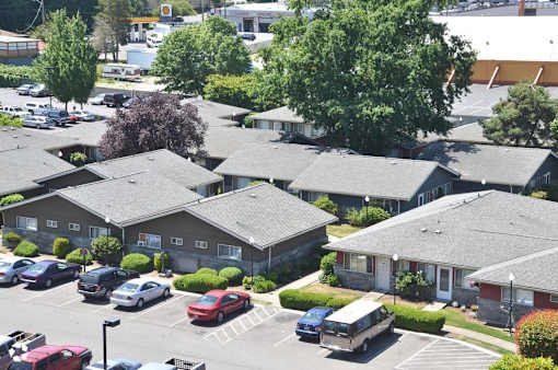 A parking lot with cars and apartment buildings in the background.