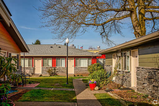 A house with a red awning and a tree in front.