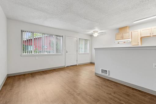 A room with a window and a wooden floor.