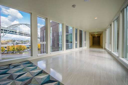 A long hallway with a view of a bridge outside the windows.