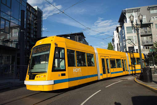 A yellow tram with the word "Horn" on it is on a street.