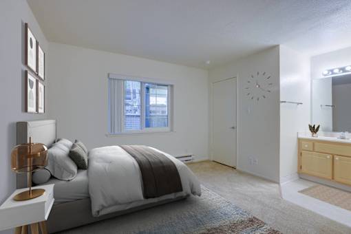 A bedroom with a bed, nightstand, and a clock on the wall.