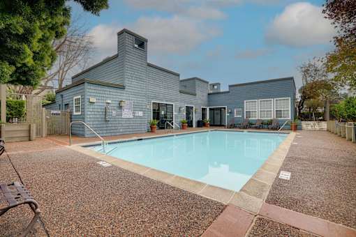 A pool in front of a grey building.
