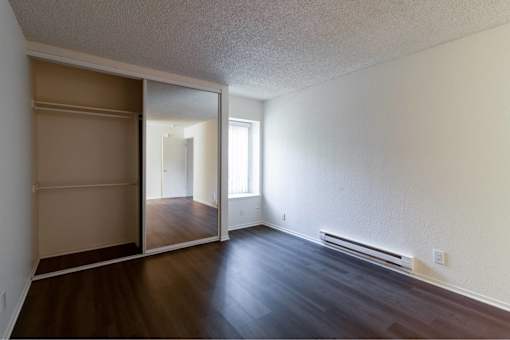 A room with a sliding door and wooden floors.
