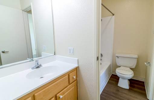 A white sink in a bathroom with a wooden drawer.