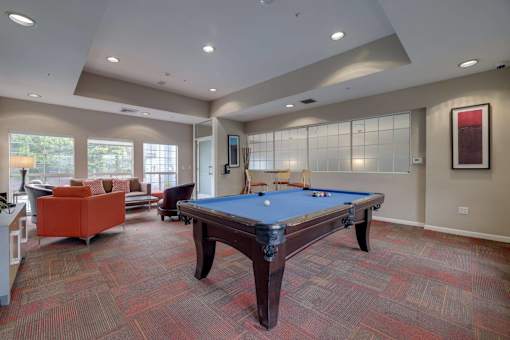 A room with a pool table and a couch.