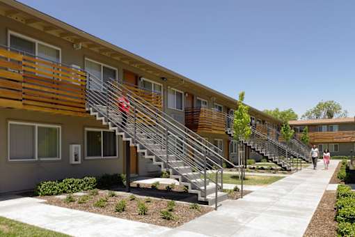 A row of modern townhouses with a woman walking in front.