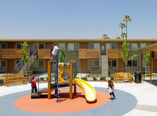 A playground with a yellow slide and a red and blue climbing frame.