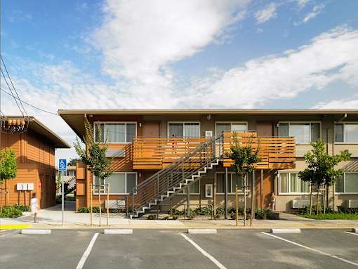 A large wooden building with a staircase leading to the entrance.