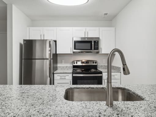 a kitchen with granite countertops and stainless steel appliances