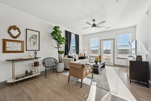 A living room with a couch, chair, and a plant.
