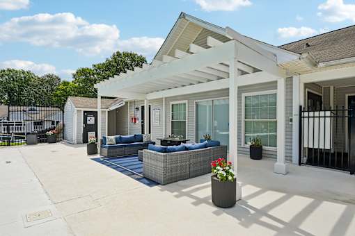 A white patio with a black railing and a white house in the background.