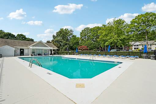 A large swimming pool with a white fence around it.