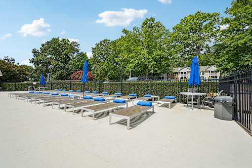 A poolside area with sun loungers and umbrellas.